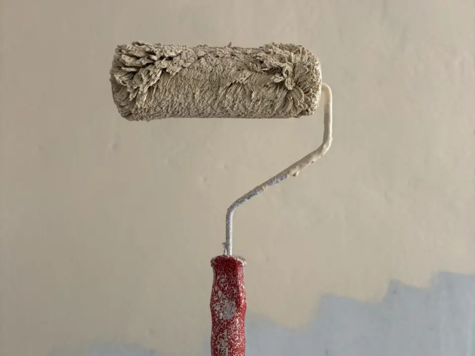 Rouleau appliquant une peinture claire sur un mur lisse