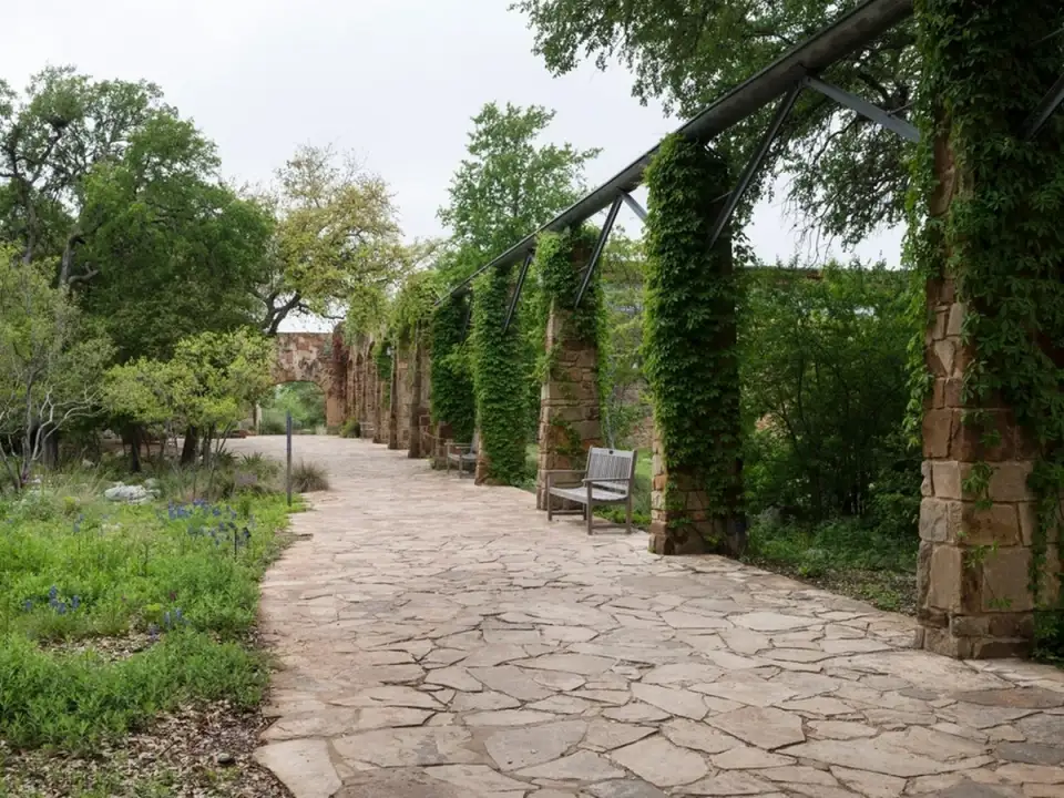 Allée dallée sous une pergola de bois et de fer
