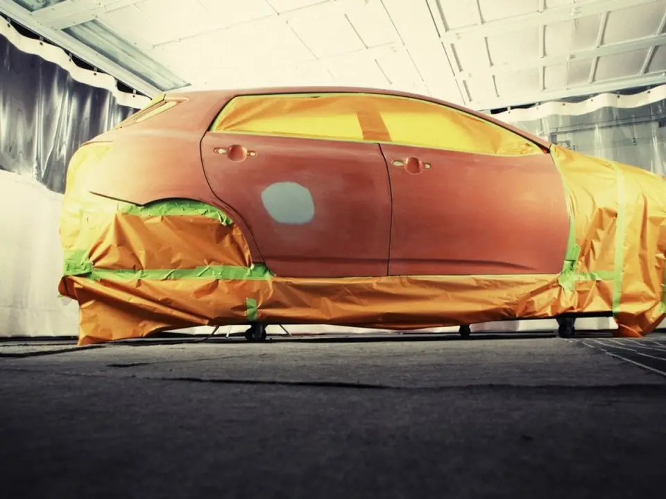 Voiture masquée de papier et de ruban, prête pour la peinture en cabine