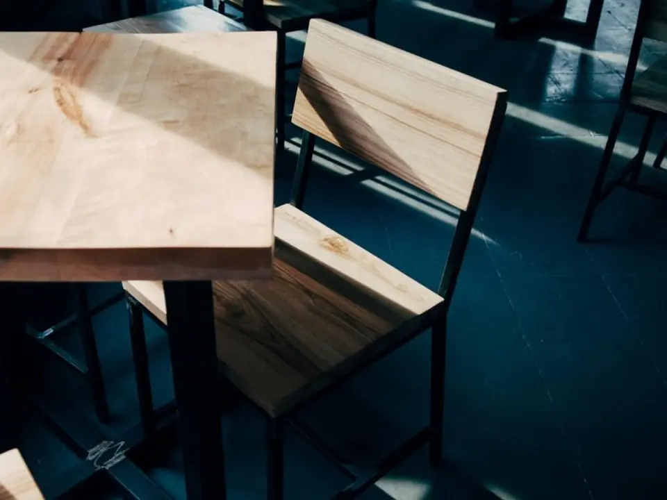 Tables en bois clair dans une salle sobre